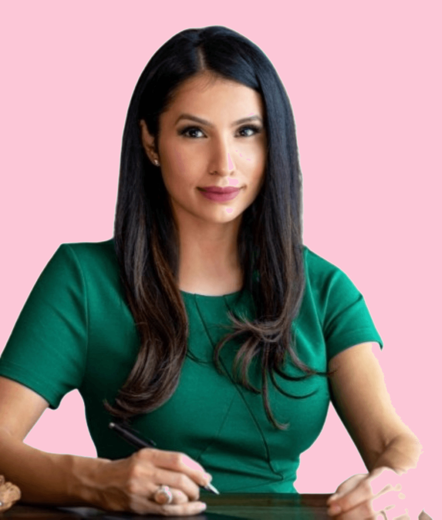 Woman with long dark hair in a green dress writing against a pink background.